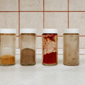 Glass spice jars with white lids filled with ground spices