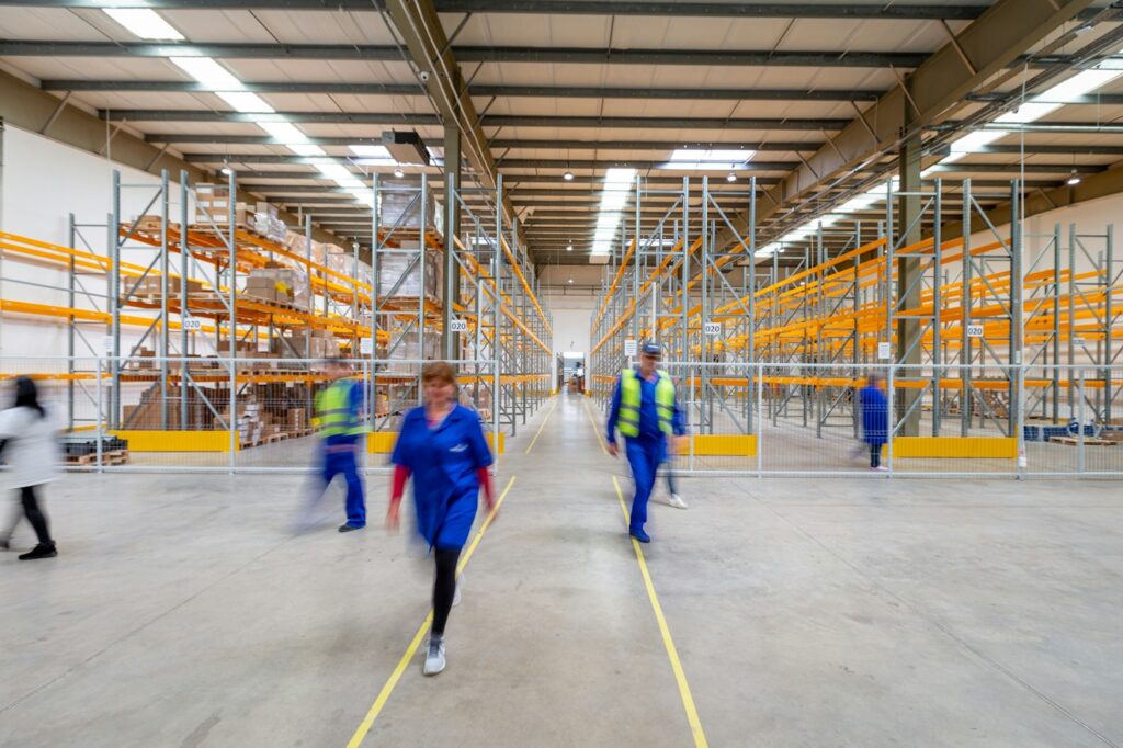 Distribution warehouse with pallet racking and staff at work